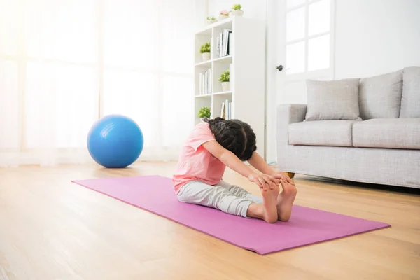 Mädchen sitzt auf dem Holzboden mit Matte — Stockfoto