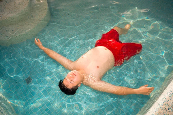 man relaxing in swimming pool bath