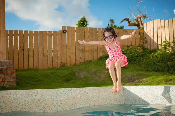 漂亮的小女孩跳进游泳池 — 图库照片