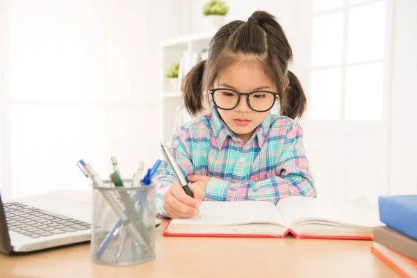 Söt flicka kid slitage glasögon på allvar skriver — Stockfoto