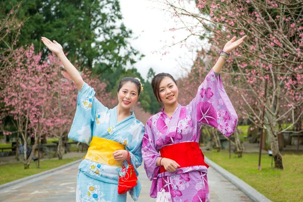 两个女人张开双臂与樱花 — 图库照片