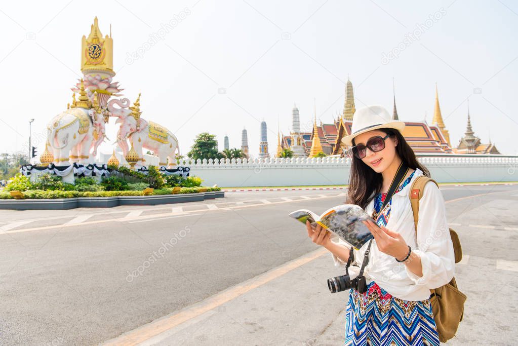 tourist with travel guide book on grand palace