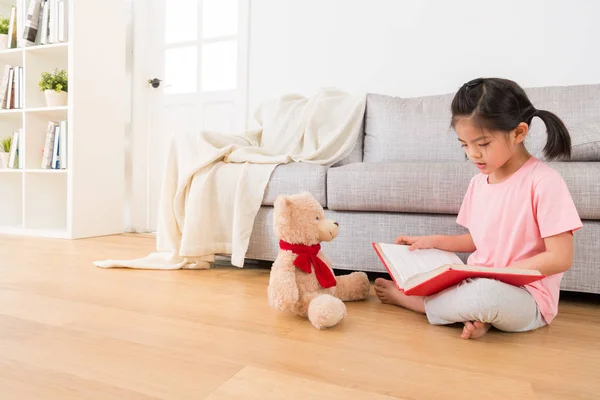 Meisje en haar teddybeer serieus bestuderen — Stockfoto