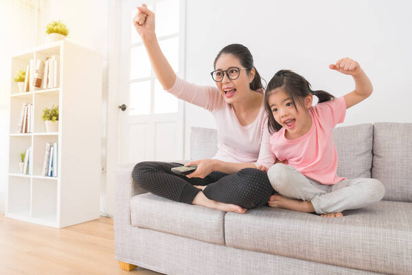 женщина с детьми смотрит спортивный телеканал
