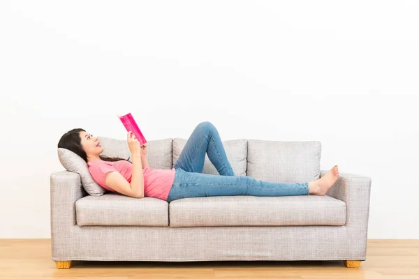Vrouw leesboek in woonkamer liggend op Bank — Stockfoto