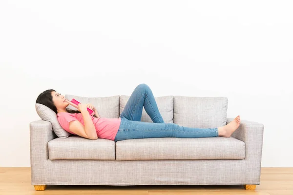 Frau mit Märchenbuch auf der Couch liegend — Stockfoto