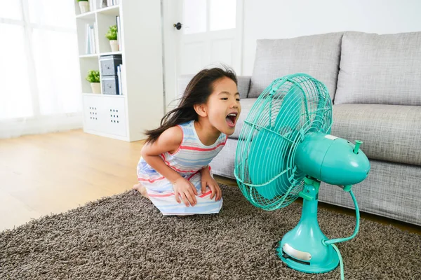 Прекрасные маленькие девочки сталкиваются с электрическим вентилятором — стоковое фото