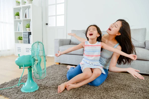 Happy little girl sitting on young mother legs — Stock Photo, Image