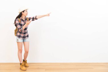 ahşap zemin üzerinde duran gülümseyen kadın backpacker