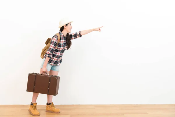 Mulher viajante atraente apontando parede branca — Fotografia de Stock
