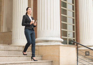 Dijital tablet ve kahve kağıt bardak tutan kadın