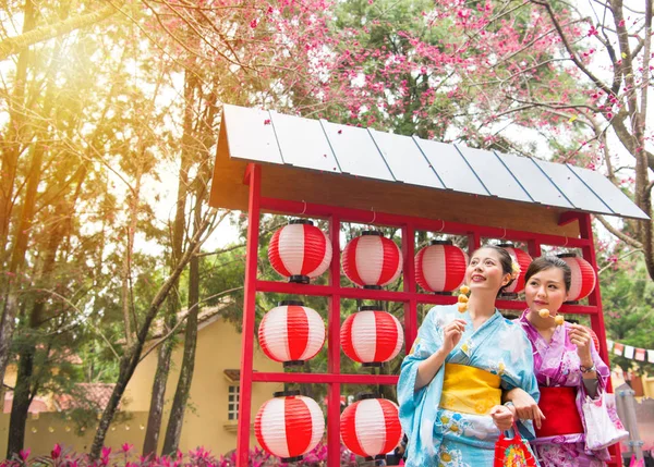 Chicas kimono tradicionales comen albóndigas fritas —  Fotos de Stock