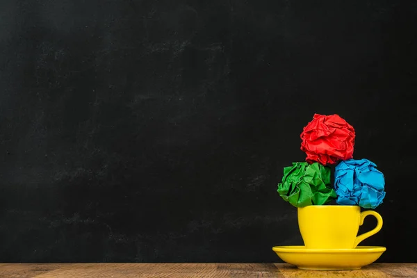 Pilha de bola de papel colorido no copo de café amarelo — Fotografia de Stock