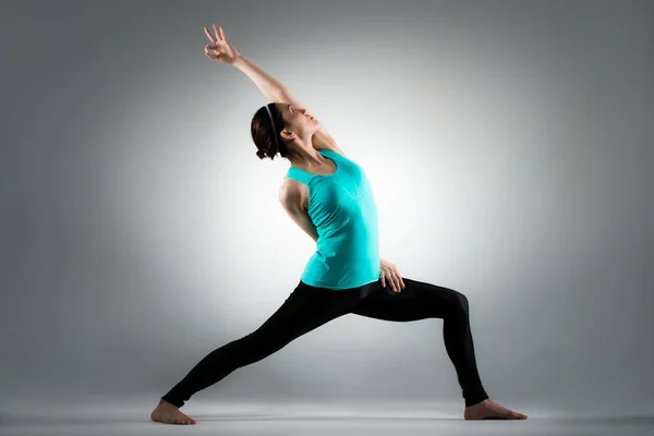 Beautiful yoga lady standing in grey background — Stock Photo, Image