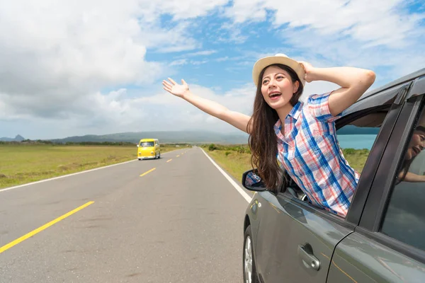 Feliz viajero femenino atascado por la ventana del coche — Foto de Stock