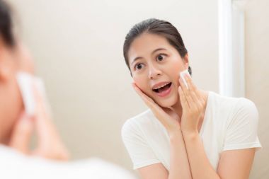 mutlu bir şekilde aynaya bakarak gülümseyen kız öğrenci