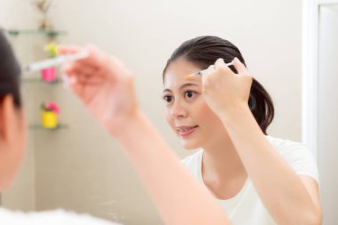 aynaya bakarak gülümseyen güzel kadın