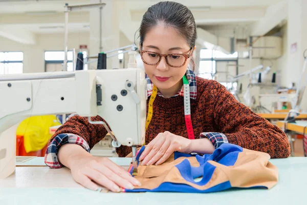 Female clothing designer using tailor machine — Stock Photo, Image