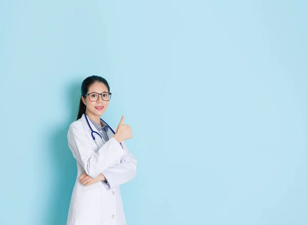 Atraente feminino médico mostrando dedo polegar para cima — Fotografia de Stock