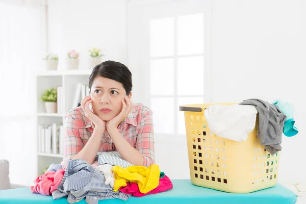 Infeliz atractiva mujer mucama plegable ropa — Foto de Stock