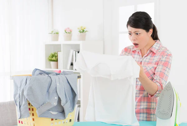 Pretty housewife doing homework in ironing board — Stock Photo, Image