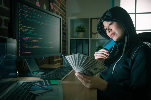 Junge lächelnde Hackerin schaut auf Banknote — Stockfoto