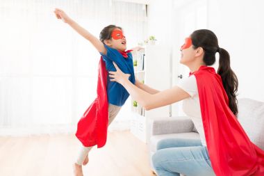 Holding sevimli küçük kız yapma sinek poz anne