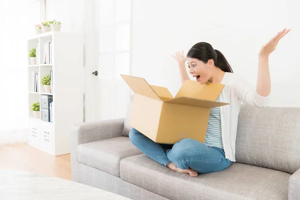 Aantrekkelijk meisje, zittend op de Bank perceel doos — Stockfoto