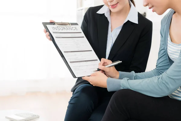 Smiling elegant female investor signing deal — Stock Photo, Image