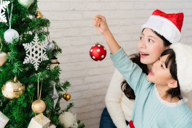 Anne ve kızı Noel ağacı süslüyorlar.