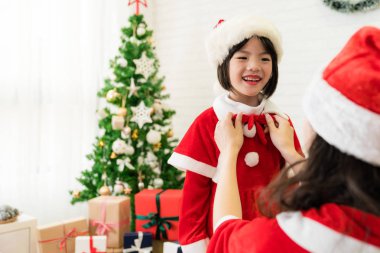 Anne yay bağlamak için onu sevimli kız yardımcı olur.