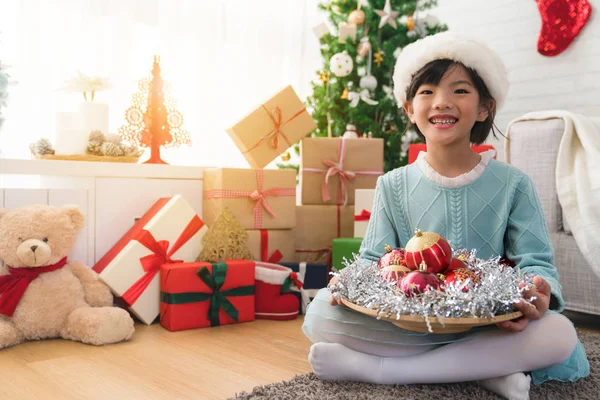 Söt asiatisk tjej håller en tallrik röd inredning — Stockfoto