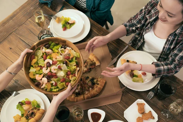 Happy friend pass salad to each other. — Stock Photo, Image