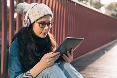 açık havada oturma ve tablet kullanma kadın