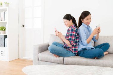 gülümseyen kız sırt sırta koltukta oturuyor.