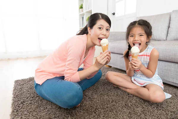 Неторопливая мать с маленькой девочкой, поедающей мороженое — стоковое фото