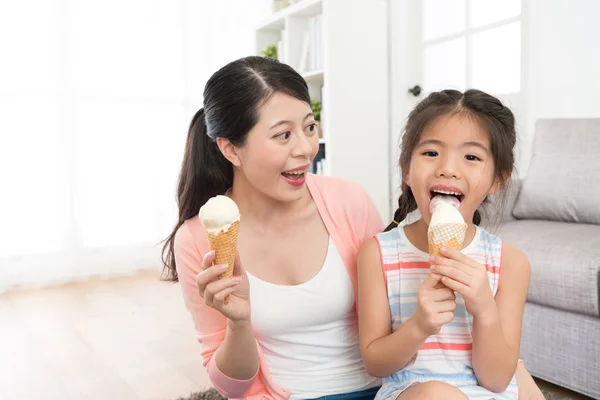 Маленькая девочка лицом к камере облизывает мороженое — стоковое фото