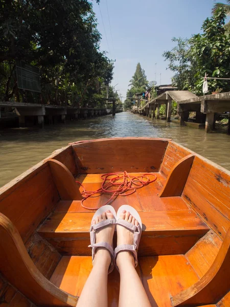 Mladá žena nosí sandály sedí na lodi — Stock fotografie