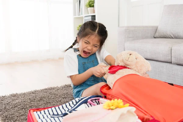 Encantadora niña tratando de tirar de su osito de peluche — Foto de Stock