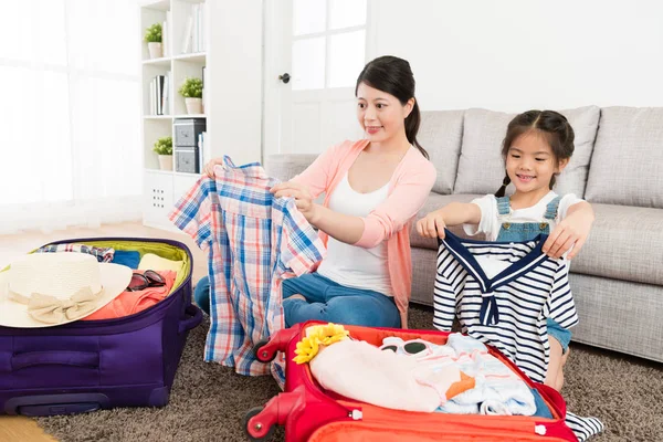 Mujer con pequeña hija joven plegable ropa — Foto de Stock