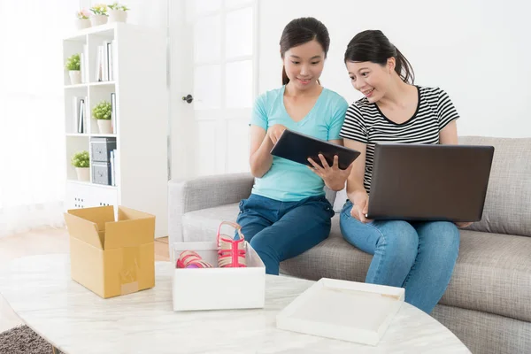 Улыбающиеся женщины онлайн покупки дома вместе — стоковое фото