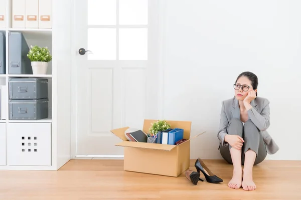 Traurige Büroangestellte sitzt auf Holzboden — Stockfoto