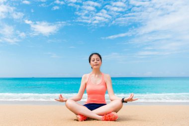 Seaside beach üzerinde oturan gülümseyen güzel yoga kadın