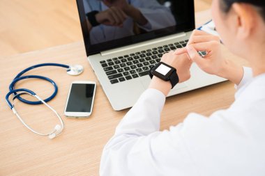 arkadan görünüşü smartwatch kullanarak genç kadın doktor