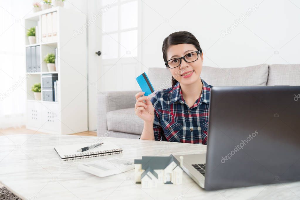 confident woman using credit card paying house tax