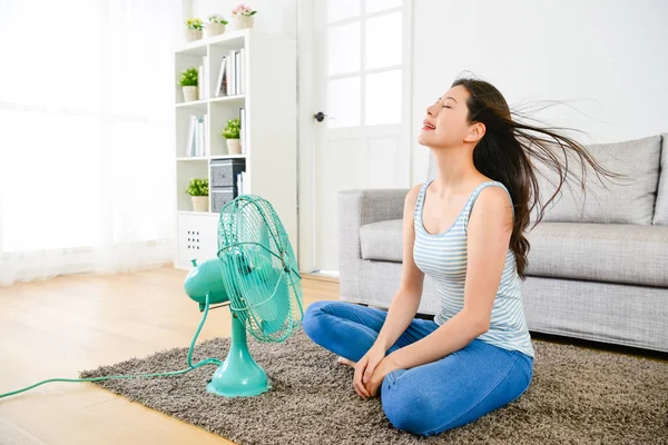 Felice donna soffiando ventilatore elettrico in giorno d'estate — Foto Stock
