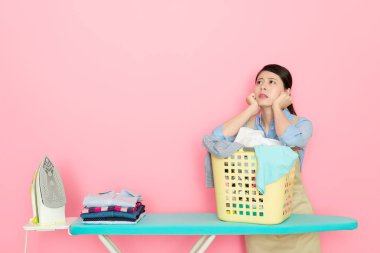 Genç houseworker kadın Ütü giyim hazırlanıyor