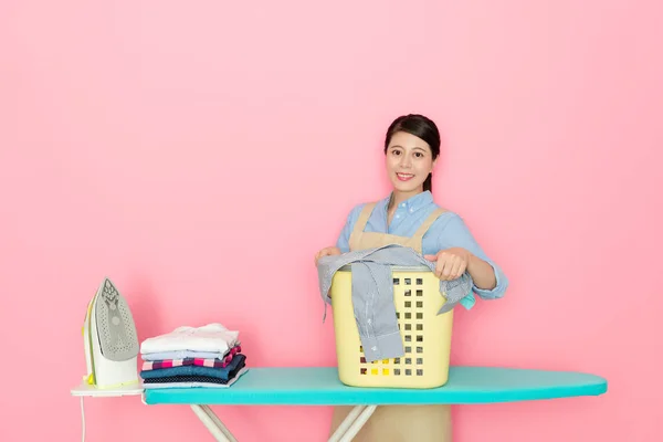 Çamaşırhane mağaza işçi pembe arka planda duran — Stok fotoğraf