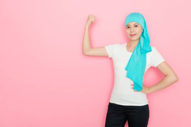 mutlu güzel kanser pembe duvar arka planda gösteren güçlü gücü kas kalan kadın ve kamera gülümseyen seyir.
