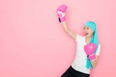 kanser hasta kalan o başarıyla boks eldivenli hastalığı yendiği pembe arka plan kutlama mutlu güzel kadın.